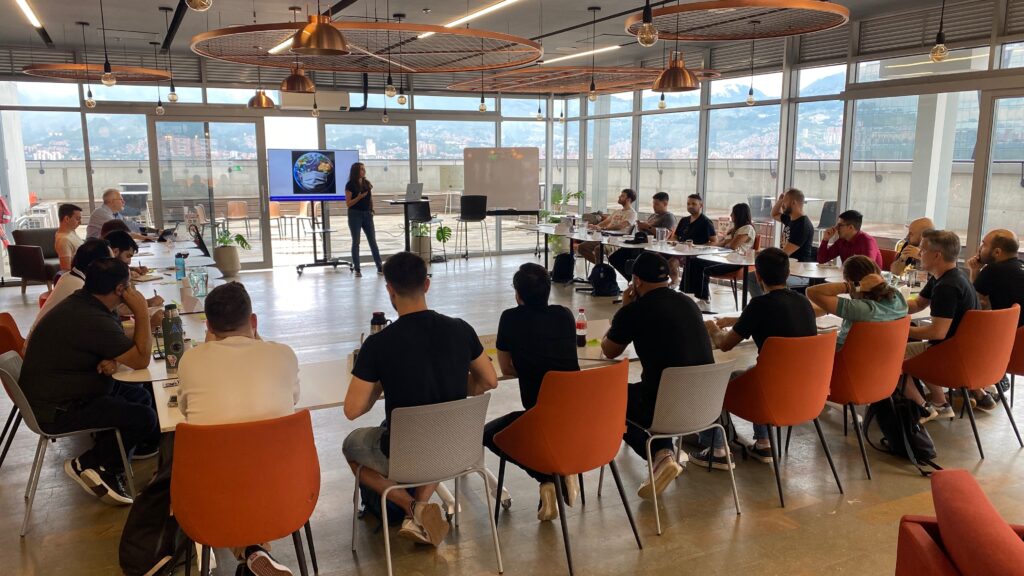 Personas participantes de WOPR Latam 2024 en Colombia comparten una sesión presencial de workshop, en un formato colaborativo que inspira la primera edición de TAPIA.